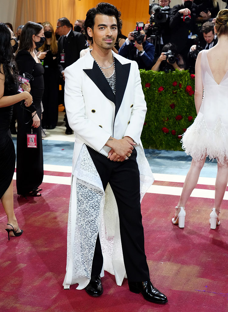 A couple that’s styled together, stays together! Along with his wife, Joe Jonas embraced sustainable fashion by wearing a womenswear tailcoat that debuted at the Louis Vuitton Spring 2022 show. The structure and silhouette of this tailcoat, along with the white lace train, make it fit the “Gilded Glamor” dress code perfectly!