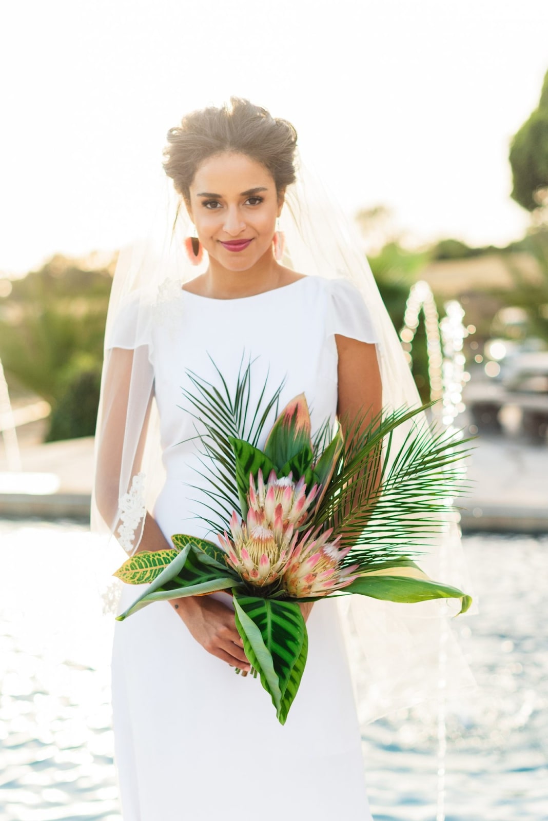 Obviously, it would be super ideal to have your wedding on the beaches of Maui. But if that isn’t in the cards, try adding some island touches to your big day and having palm leaf fans instead of traditional bouquets.
